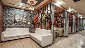 a waiting room with two couches and flowers on a wall at Utkarsh Hotel & Lodging in Jāmkhed +23 photos