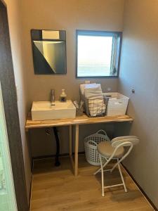 a bathroom with a sink and a mirror and a chair at ダイヤモンドヘッドいすみ in Chōjamachi