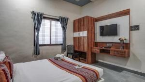 a hotel room with a bed and a television at Utkarsh Hotel & Lodging in Jāmkhed