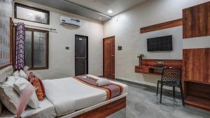 a bedroom with a bed and a desk in it at Utkarsh Hotel & Lodging in Jāmkhed