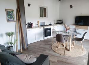a kitchen with a table and chairs in a room at Le Lys des Makes in Saint-Louis