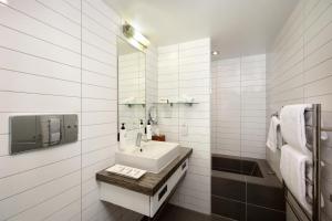 a white bathroom with a sink and a mirror at Swiss-Belsuites Pounamu Queenstown in Queenstown +29 photos