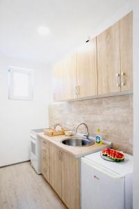 a kitchen with wooden cabinets and a sink at Tomm in Trebinje