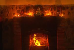 a fireplace with candles and a fire in it at Hullathy by Red Earth in Ooty