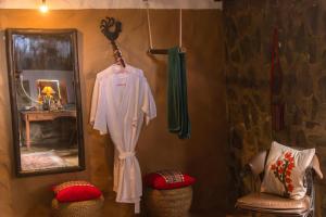a robe hanging on a wall next to a mirror at Hullathy by Red Earth in Ooty