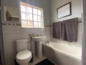 a bathroom with a toilet and a sink and a tub at Manasseh in Riversdale
