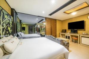 a hotel room with a bed and a flat screen tv at S One Hotel in Busan