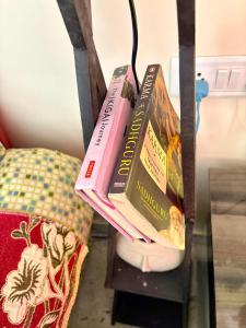 three books sitting on top of a shelf at Perth villa in Mount Ābu