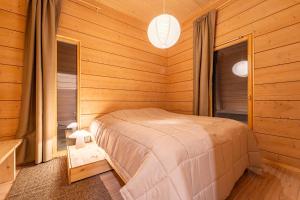 a bedroom with a bed in a wooden room at Lakeside Cabin in Romakkaniemi