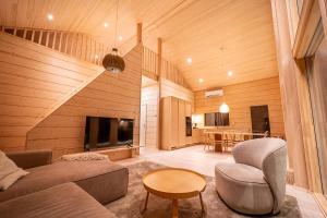 a living room with a couch and a tv and a table at Lakeside Cabin in Romakkaniemi
