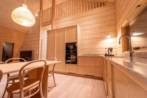 a kitchen with wooden walls and a wooden table and chairs at Lakeside Cabin in Romakkaniemi