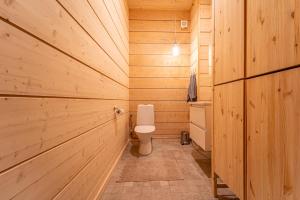 a bathroom with a toilet in a wooden wall at Lakeside Cabin in Romakkaniemi +32 photos