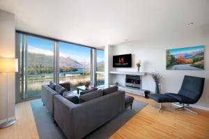 a living room with a couch and a chair at Swiss-Belsuites Pounamu Queenstown in Queenstown