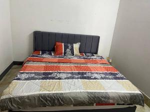 a bed with a quilt on it in a room at Frog Guesthouse in Phnom Penh