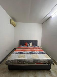 a bedroom with a bed in a white room at Frog Guesthouse in Phnom Penh