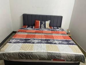 a bed with a quilt on it in a room at Frog Guesthouse in Phnom Penh