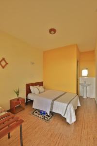 a bedroom with a bed with a yellow wall at Budget Gest House in Lalibela