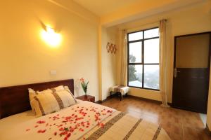 a bedroom with a bed with red flowers on it at Budget Gest House in Lalibela