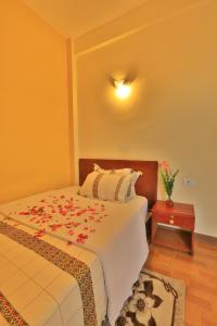 a bedroom with a bed with flowers on it at Budget Gest House in Lalibela