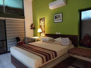 a bedroom with a bed and a green wall at Mi casa in Kandy