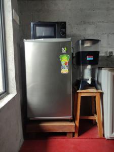 a stainless steel refrigerator with a microwave on top of it at Mi casa in Kandy