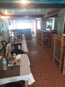 a restaurant with tables and chairs and a bar at The Garden Tropical Cabins in Basdiot