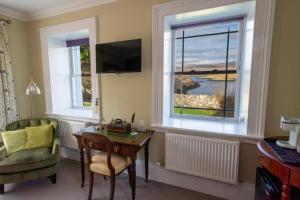 a room with a table and a chair and a window at Two Harbours Guest House in Scalpay