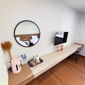 a room with a table with a mirror and a television at Ma Relax Place in Ban Nong Chaeng