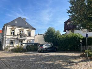 a car parked in front of a white house at Casa Ribeiro Sotao in Bischberg