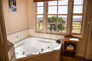 baño con bañera grande y ventana en Hillview Cottages, en Kingaroy