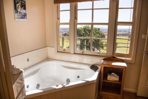 a large bath tub in a bathroom with a window at Hillview Cottages in Kingaroy
