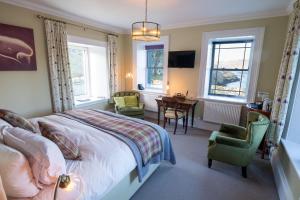 a bedroom with a bed and a table and chairs at Two Harbours Guest House in Scalpay