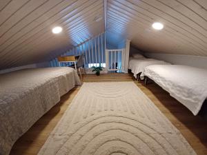 a attic bedroom with two beds and a rug at Villa Anilia in Syöte