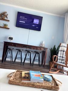 a living room with a piano with a tv on the wall at Boltons Bungalow Casa Del Mar in Galveston
