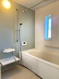 a bathroom with a bath tub and a sink at Akikawa Toshima 2 プレミアム鉄骨 一棟貸切ヴィラ in Kumamoto +14 photos