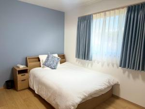 a small bedroom with a bed and a window at Akikawa Toshima 2 プレミアム鉄骨 一棟貸切ヴィラ in Kumamoto