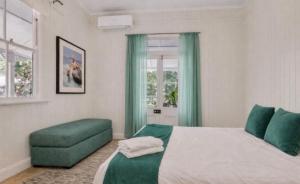 a bedroom with a bed and a green ottoman at Addisons Baroon A Rainforest Retreat with Heated Plunge pool in Montville +27 photos