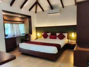 a bedroom with a large bed with red pillows at Misty Grove Resort in Devāla +19 photos