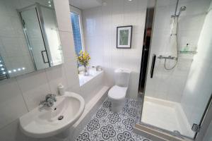 a bathroom with a sink and a toilet and a shower at Two Harbours Guest House in Scalpay