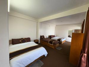 a hotel room with two beds in a room at Delohighs in Kalimpong