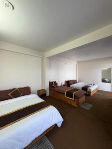 a hotel room with two beds in a room at Delohighs in Kalimpong