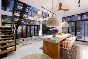 a kitchen with a staircase and a table with chairs at Baliwood Residence Villas by BREIG in Munggu
