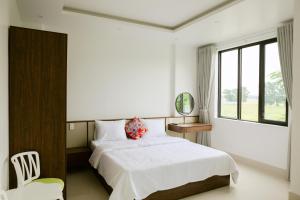 a bedroom with a white bed and a window at Cloud Inn Homestay in Thôn Lại Thê