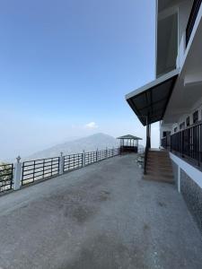 a balcony of a building with a view of the ocean at Delohighs in Kalimpong