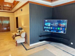 a living room with a flat screen tv on a wall at Pent House Executive Resedency in Dargai