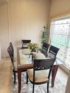 a dining room with a table and chairs with flowers on it at Pent House Executive Resedency in Dargai