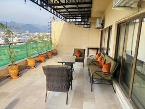 a balcony with chairs and tables on a building at Pent House Executive Resedency in Dargai