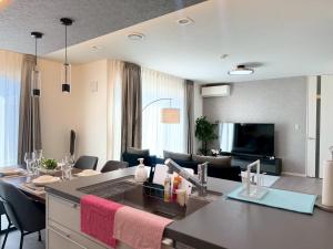 a living room with a kitchen and a living room with a couch at Akikawa Toshima 2 プレミアム鉄骨 一棟貸切ヴィラ in Kumamoto