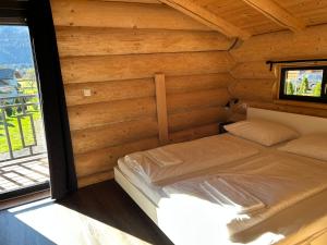 a small bed in a wooden room with a window at Luxus Chalet nähe Skipiste in Jenig