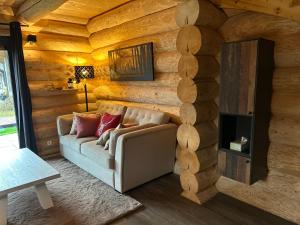 a living room with a couch in a log wall at Luxus Chalet nähe Skipiste in Jenig
